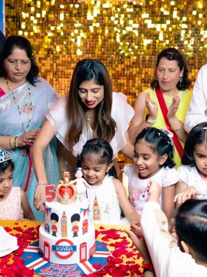 The birthday girl, Kiara, and her friends getting ready to cut her special London-themed cake.