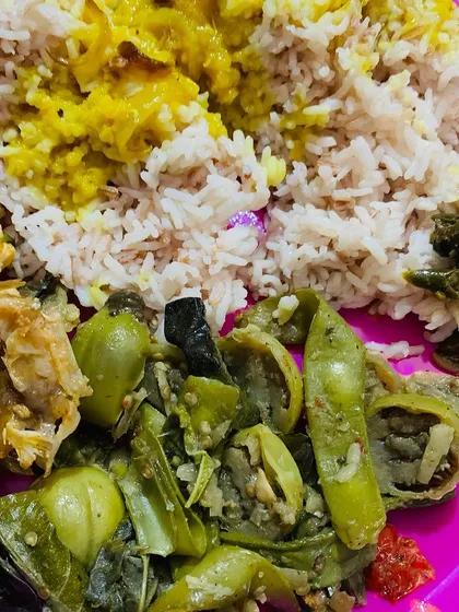 Another plate with fish head curry, dal, rice, and a side of boiled vegetables.