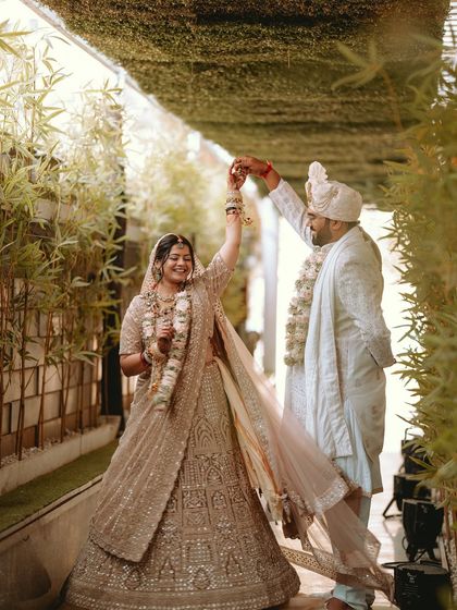 A joyful twirl in the midst of a beautiful green walkway, the couple celebrating their new union.
