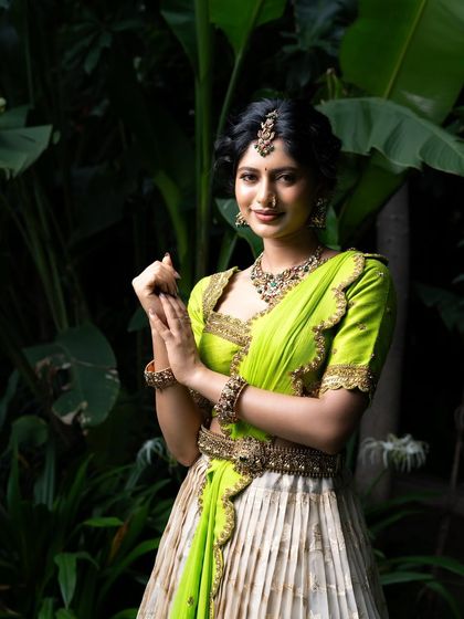 Wrapped in elegance, this half saree features a light gold tissue lehenga paired with a vibrant lime green princess katori blouse. The entire ensemble, including the dupatta, is finished with intricate handwork for a look of traditional grace.