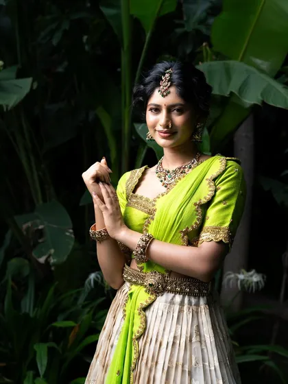 Wrapped in elegance, this half saree features a light gold tissue lehenga paired with a vibrant lime green princess katori blouse. The entire ensemble, including the dupatta, is finished with intricate handwork for a look of traditional grace.