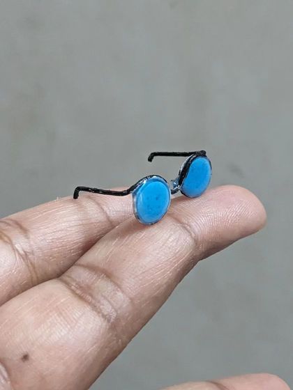 A teeny tiny pair of goggles, resting on my fingertip. I love making these miniature accessories to add detail and personality to my figurines.