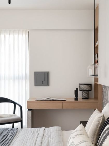 An elegant backdrop and warm herringbone flooring create a harmonious space in this master bedroom and study. Carefully chosen furnishings and textures bring together modern design and natural elements, embodying a sense of quiet luxury.