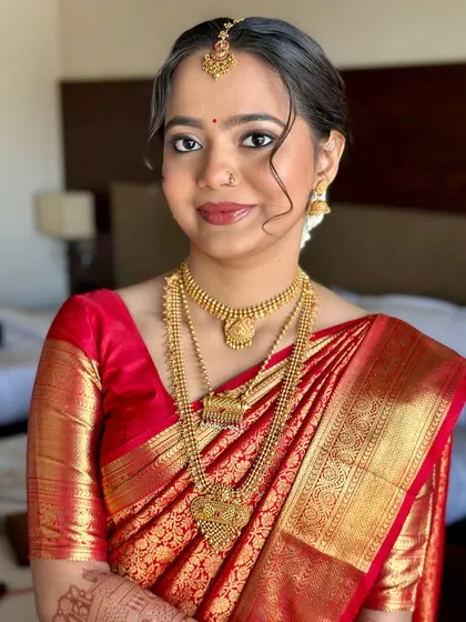 A wedding day glow with a touch of Maharashtrian magic. This bride in her red silk saree looks absolutely timeless with classic gold jewelry and soft, elegant makeup.