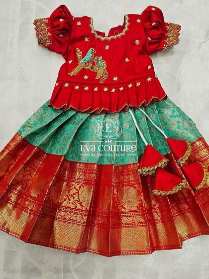 A newborn-sized red and green Pattu Pavadai with bird embroidery on the blouse.