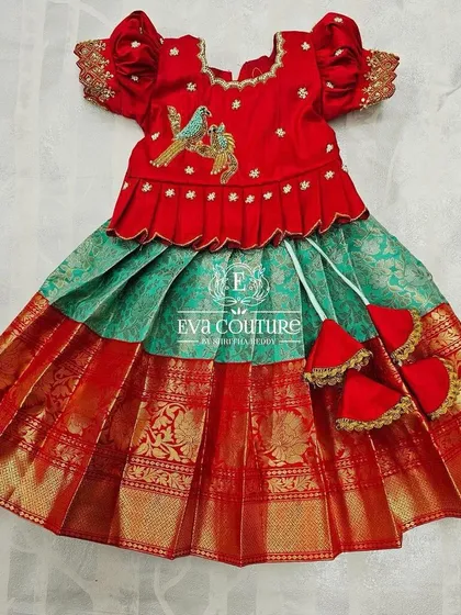 A newborn-sized red and green Pattu Pavadai with bird embroidery on the blouse.