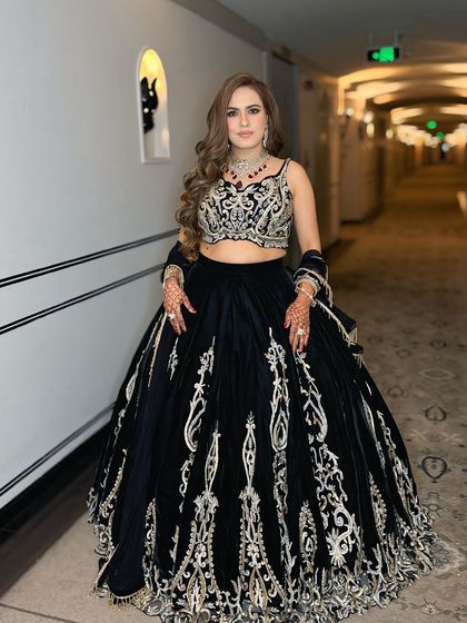 A full-length shot of the client in her beautiful black lehenga. The makeup is glamorous and camera-ready.