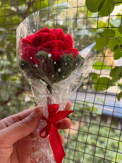 A single red rose, individually wrapped and held in hand. It's a small but meaningful gift that says you care.