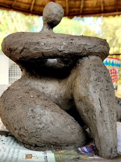 An abstract sculpture capturing the form of a seated figure, created using a rough, expressive hand-building technique. This piece celebrates the beauty of the raw, unfinished texture of the clay.