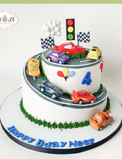 Kachow! A two-tiered racetrack cake inspired by the movie "Cars." Featuring Lightning McQueen, Mater, and their friends racing up the spiraling road, it's a dream cake for any little racing fan.
