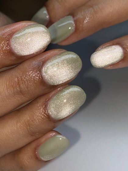 A unique olive green cat-eye manicure. The magnetic shimmer creates a silvery-white band of light that contrasts beautifully with the earthy green base.