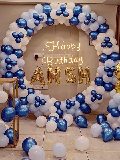 A classic blue and white balloon ring, perfect for a boy's birthday. The design includes foil letters for the name 'ANSH' and a number '8' balloon, making it a personalized and fun setup.