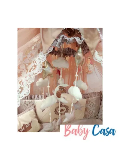 A whimsical mobile designed to match the royal bedding set. It features soft, plush clouds, stars, and a tiny bear, all hanging from a lace-trimmed canopy to gently soothe the baby to sleep.