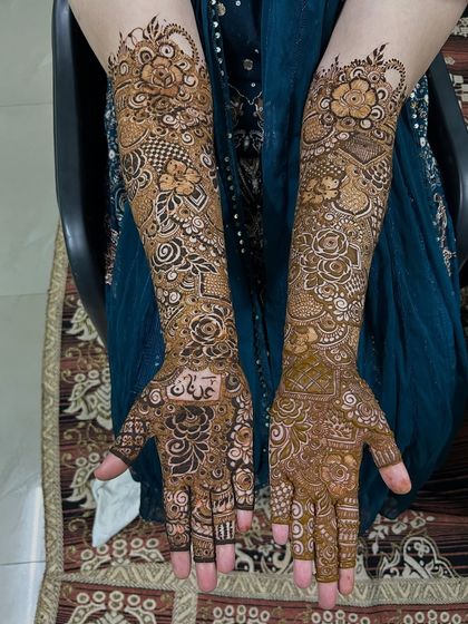 The palms of this bridal floral design, featuring the groom's name beautifully written in Arabic script.