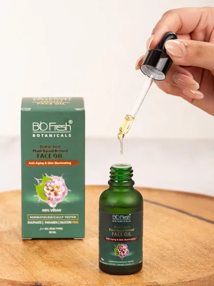An action shot showing a drop of face oil being dispensed from a dropper. This close-up is perfect for demonstrating the product's texture and purity for Biofresh Botanicals.