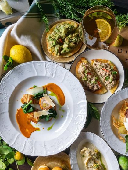 A closer look at the Italian spread, showing the beautiful plating of dishes like the Calabrian Chicken and Tuna Pizzette.