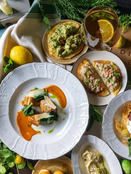 A closer look at the Italian spread, showing the beautiful plating of dishes like the Calabrian Chicken and Tuna Pizzette.