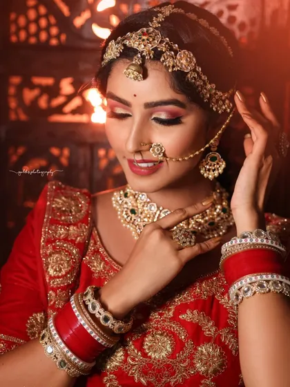 This close-up focuses on the details of the bridal look, from the heavy bangles to the delicate nose ring and the precise makeup. It's a celebration of the artistry involved in bridal preparation.