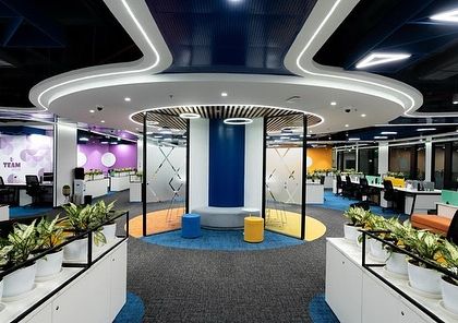 A vibrant and collaborative workspace designed for Tata Consumer Products. The planters on top of the storage units add a layer of green to the colorful and dynamic office environment.
