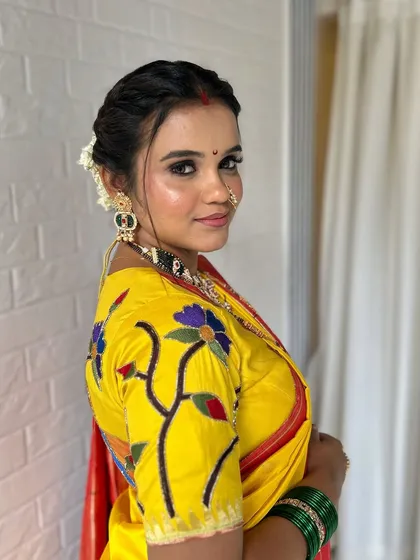 This look is all about minimal yet magical Maharashtrian bridal beauty. I created a dewy, fresh skin base with a sharp winged eyeliner and a traditional nath, complemented by a simple floral bun for timeless elegance.