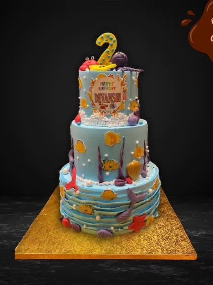 This three-tier underwater adventure cake is perfect for a second birthday. The design features multiple shades of blue, edible corals, fish, and a friendly octopus, creating a vibrant deep-sea scene.