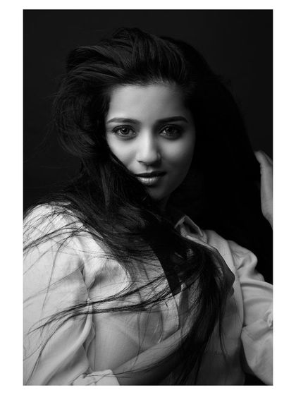 A classic portrait where the wind adds a touch of life. The black and white conversion brings out the texture of her hair and the honesty in her expression, resulting in a simple yet captivating headshot.