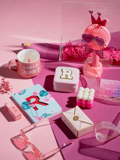 The 'Pretty in Pink' hamper deconstructed, showing off the 'Makeup Junky' mug, personalized notebook and coasters, and other fun, pink-themed items.
