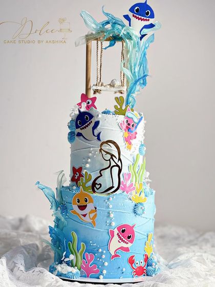 Another view of the Baby Shark swing cake, showing the cute character toppers and rice paper "splashes" that bring the theme to life.