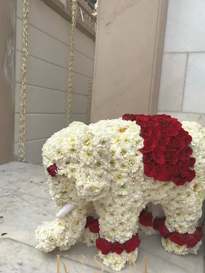 This majestic elephant, sculpted from white chrysanthemums and red roses, is a perfect example of my ethnic floral decorations. It brings a sense of royal grandeur and fragrant beauty to any celebration.