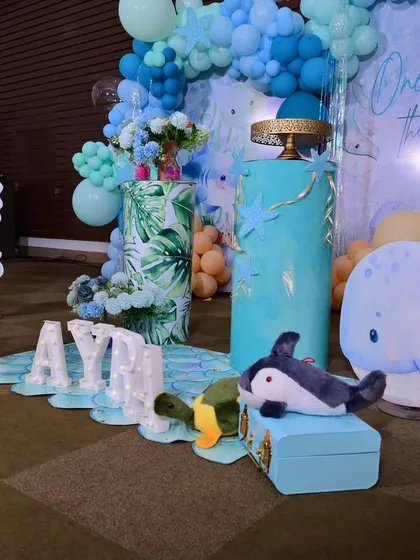 A detailed view of the floor setup, showing the 'AYRA' marquee letters on a mermaid-scale mat, surrounded by sea creature props.