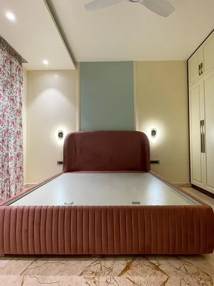 We call this the 'Rose' room, designed with a soft, dusty rose upholstered bed. The fluted detail on the bed frame adds a contemporary texture to the romantic color.