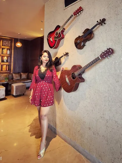 A red printed romper for a birthday celebration, styled with gold heels for a touch of glam.