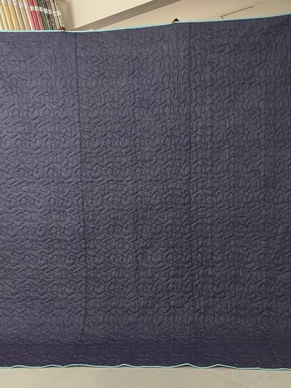 The solid grey backing, which highlights the quilting texture.