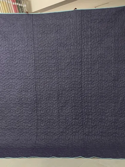 The solid grey backing, which highlights the quilting texture.