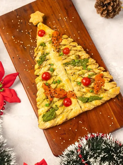 It's beginning to taste a lot like Christmas. This festive puff pastry tree, decorated with pesto and cherry tomatoes, is a fun and delicious centerpiece for your holiday table.