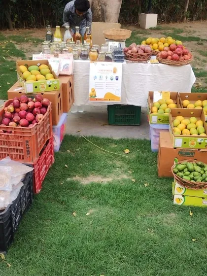 A fruit stall with crates of apples and mangoes, ready for a busy market day.