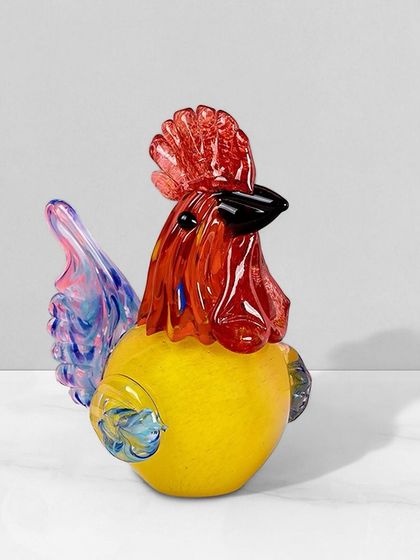 This colorful handblown glass rooster is a fun and charming decorative piece. The vibrant mix of red, yellow, and blue makes it a cheerful accent for a kitchen or living room.