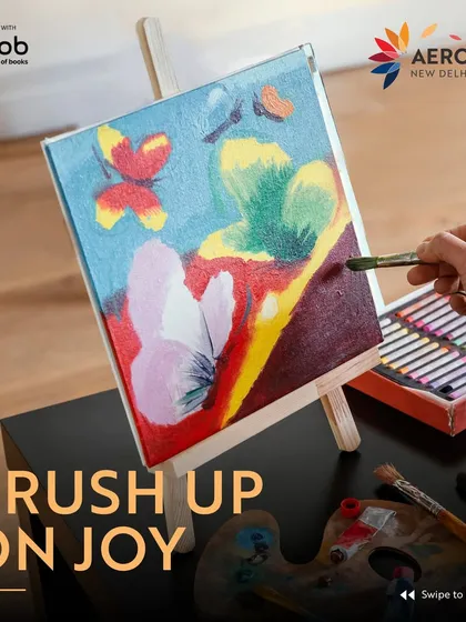 "Brush Up On Joy." A vibrant image of a hand painting a colorful canvas, promoting an art workshop where guests can learn to paint stunning landscapes with acrylics.