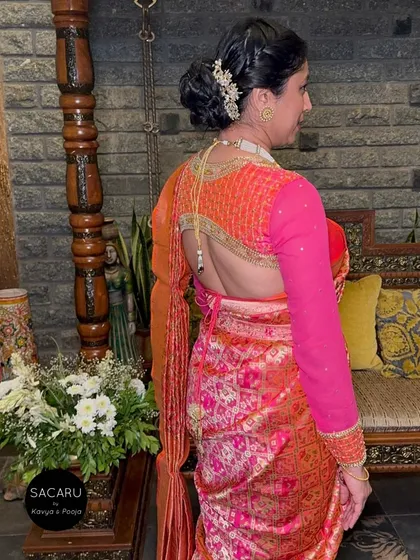 A client turning heads in a backless, full-sleeve blouse with elaborate embroidery, paired with a vibrant patola saree.