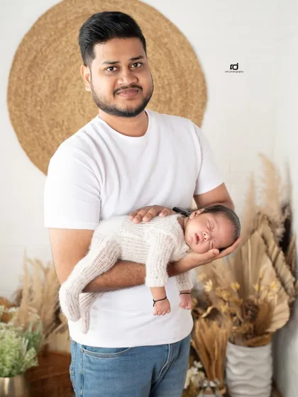 A father's strong and gentle hands holding his tiny baby. This portrait beautifully contrasts the father's strength with the newborn's delicate size.