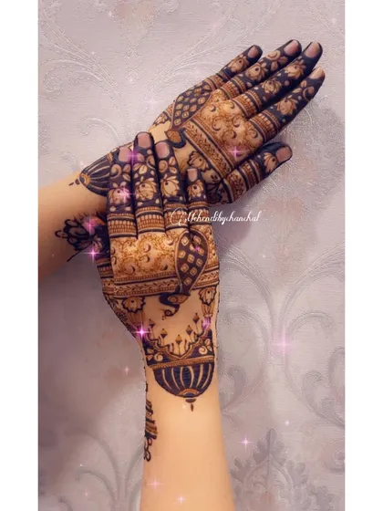 A close-up of the back of the hands, showing the delicate hanging dome (gumbad) motifs.