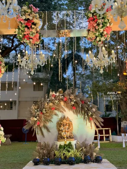 A wider view of the Ganesha setup, framed by hanging chandeliers and floral arrangements, creating a truly divine atmosphere.