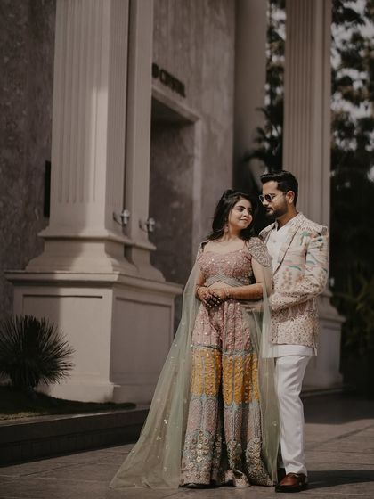 A classic portrait of the couple standing before a modern column. Their elegant pose and stunning attire create an image of contemporary grace and style.