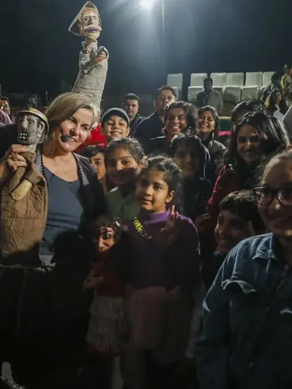 The performers from 'Mamulengo de la Mancha' pose with their puppets and happy audience members after the show.