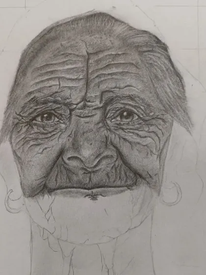 Here, the portrait is further along. You can see more definition in the eyes and forehead as the shading becomes more complex, showing the patient process of developing a realistic drawing.
