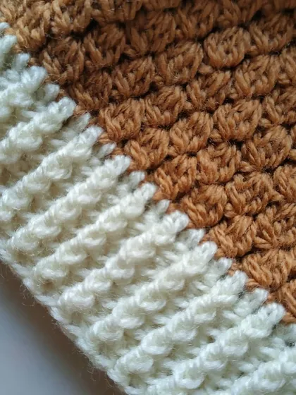 Detail of the ribbed brim on the tan Flora beanie. This technique creates a stretchy fabric that ensures a comfortable fit.