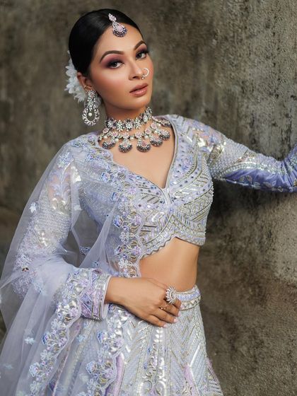 A poised shot of the pastel lavender lehenga, showing off its full sleeves and the delicate shimmer of the fabric.