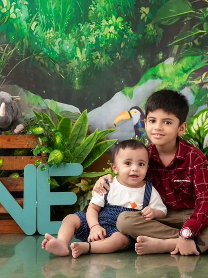 A portrait of brotherly love amidst the birthday fun. Before the cake smash, we captured this sweet moment of the two brothers in our detailed jungle-themed setup.