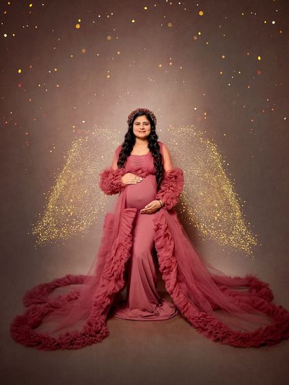 A magical solo portrait in a dusty rose ruffled gown. We added sparkling angel wings to create a truly ethereal and heavenly image of the mother-to-be.