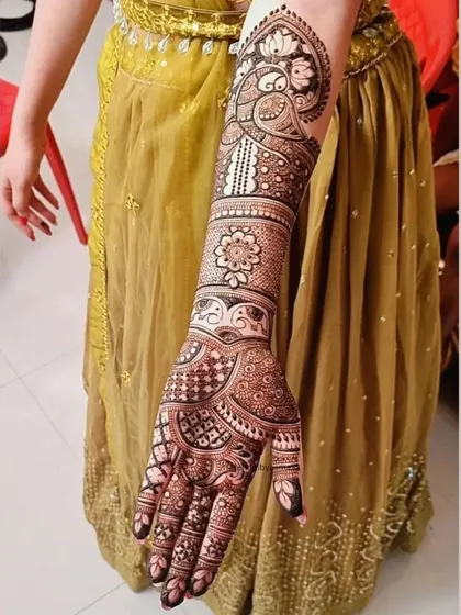 A classic bridal look featuring a majestic peacock, a symbol of grace and beauty, surrounded by detailed patterns up the arm.